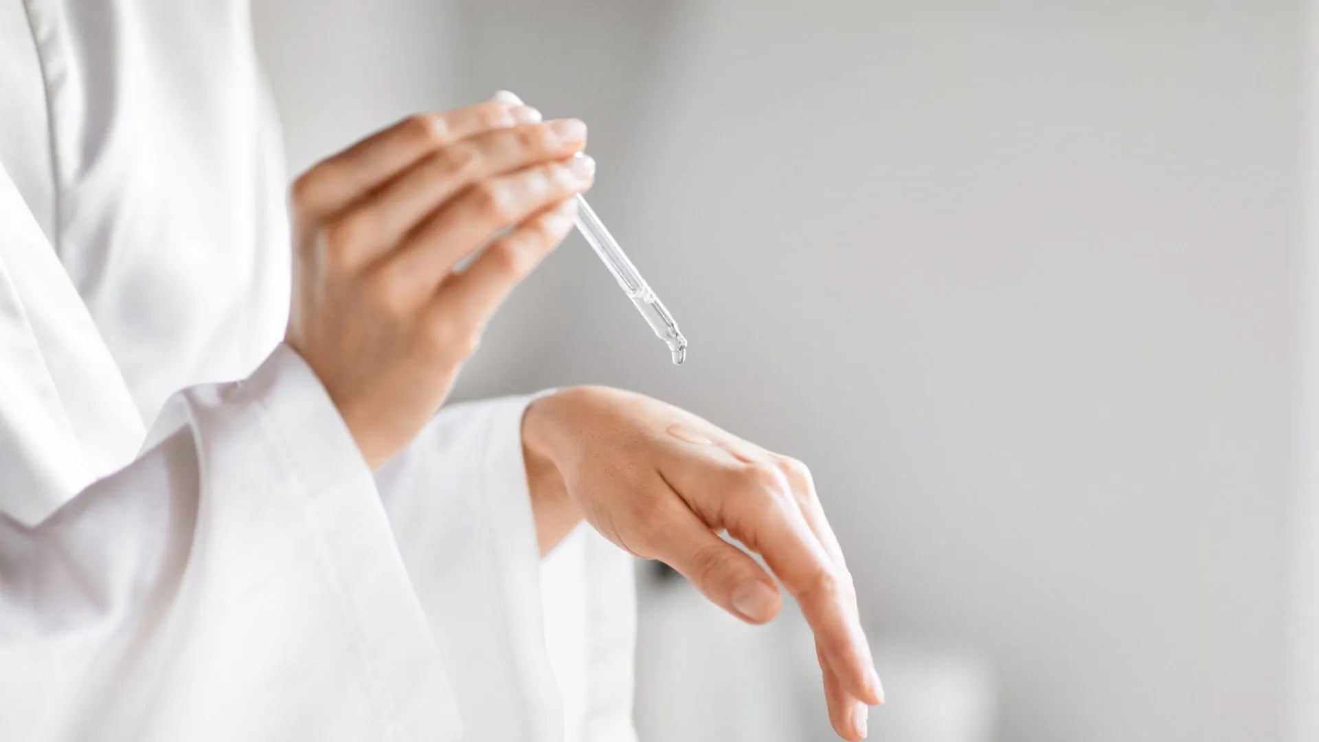 Frau tropft mit Pipette auf ihre Hand | Beauty Fellows